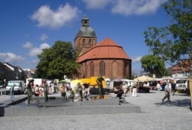 Im Hintergrund des Fotos ist die Stadtkirche Sankt Marien, ein Backsteinbau aus dem 13. Jahrhundert, zu sehen, die sich  an der Westseite des  Ribnitz-Damgartener Marktplatzes befindet! Davor entsteht demnächst das Bernstein-Café